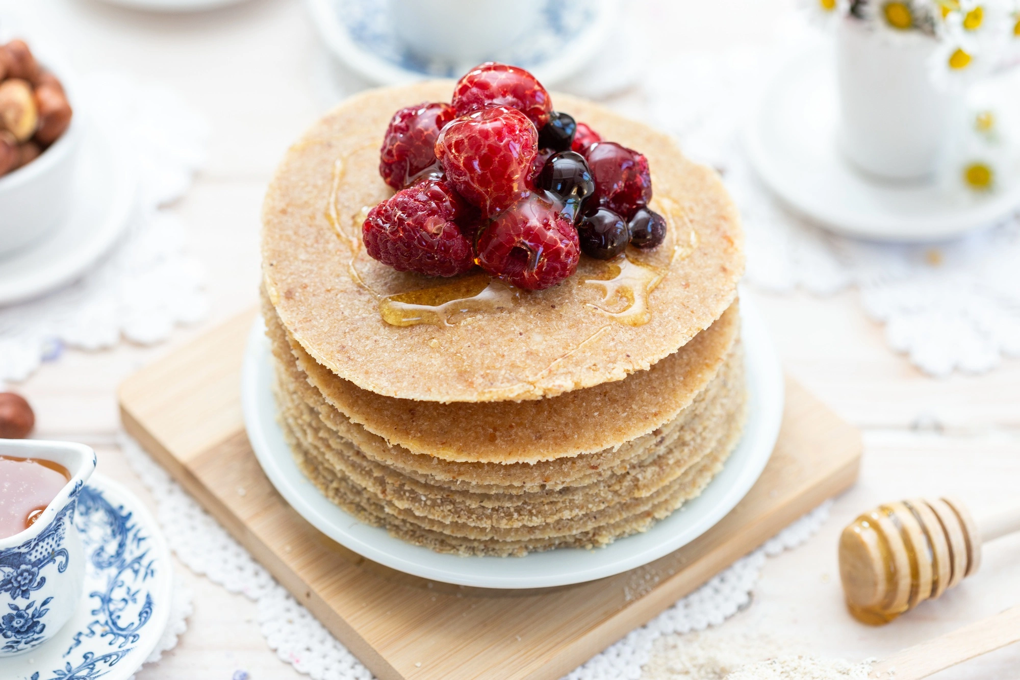 A stack of golden, fluffy pancakes made from a pancake recipe without eggs, topped with fresh berries and drizzled with honey.